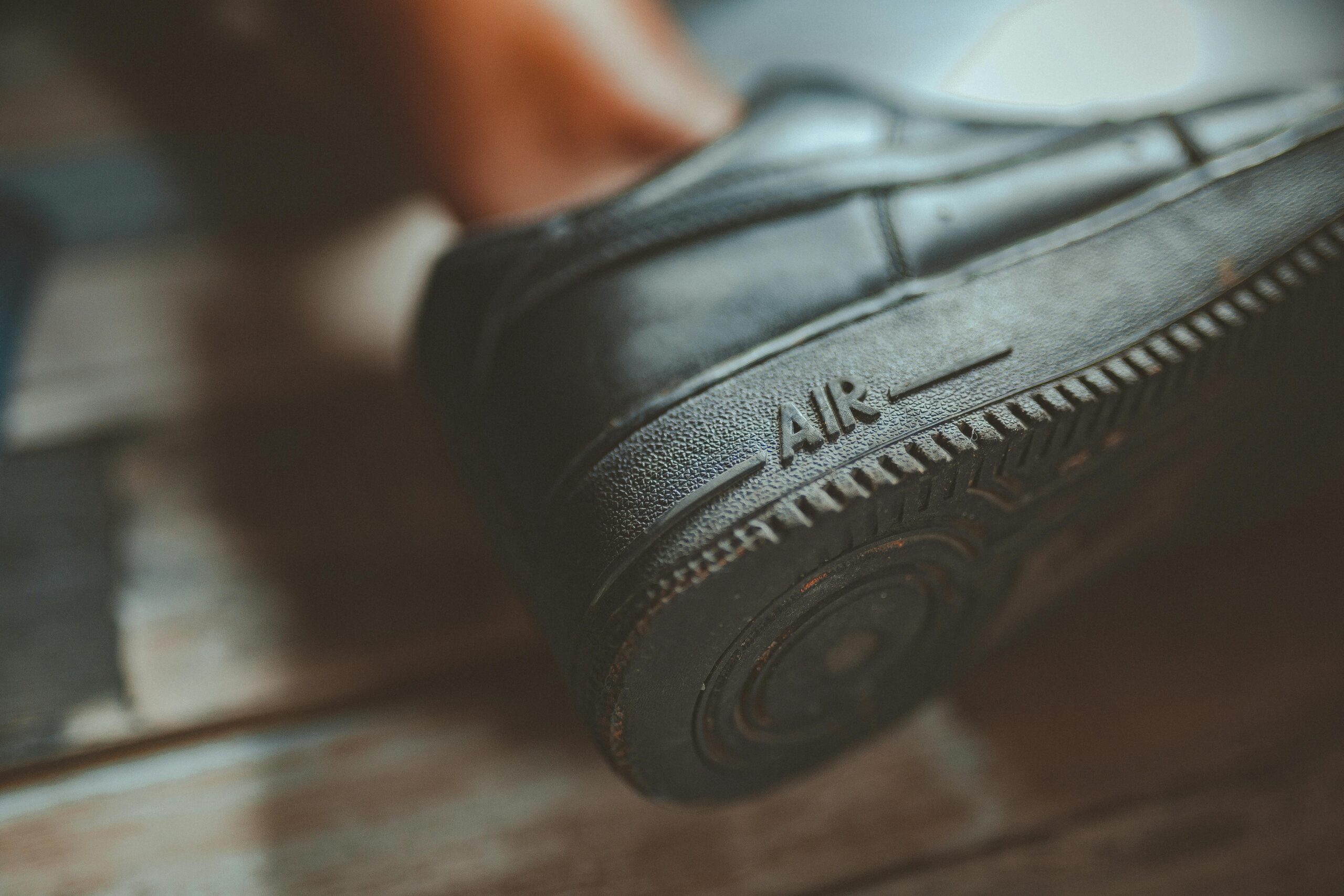 Close-up of a black sneaker sole showing text 'Air.' Focus on details and texture of the rubber material.