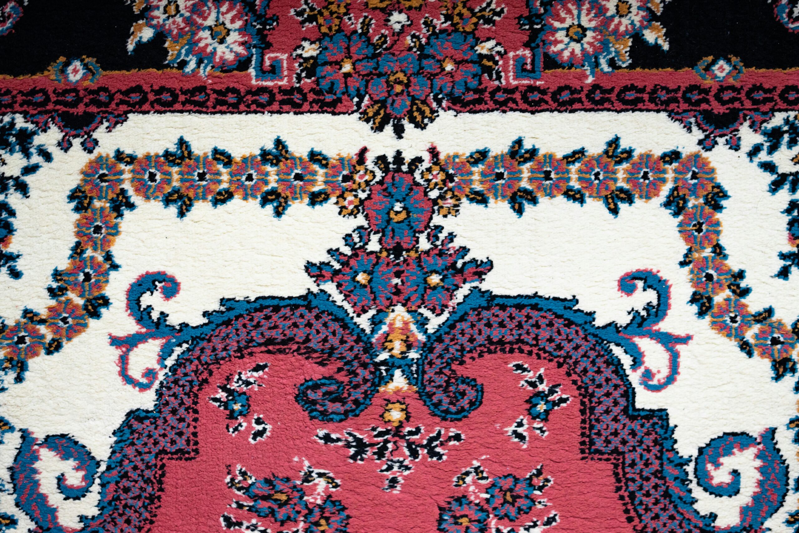 Close-up of a colorful Persian rug with intricate floral patterns and vibrant colors.